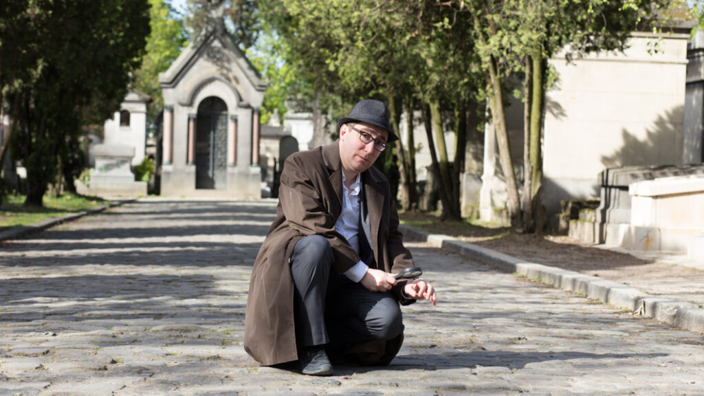 Comédien en costume dans le cimetière du Père-Lachaise lors d'une visite enquête à Paris.